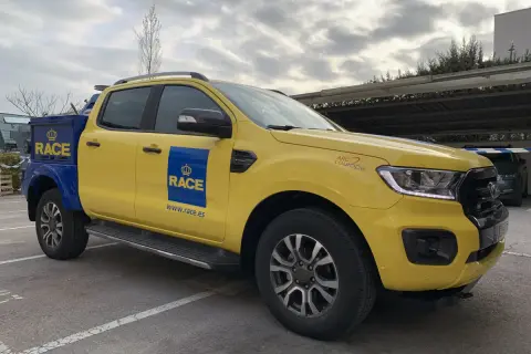 Camioneta amarilla y azul del RACE, lista para la acción. Su diseño es ideal para cualquier tipo de carrera o servicio.