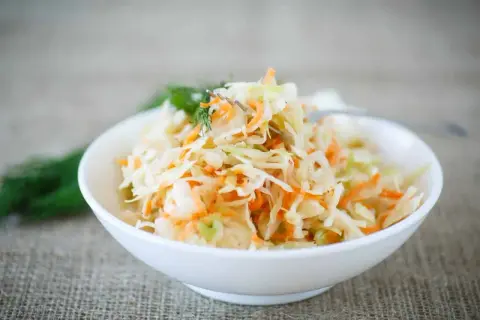 Salade de chou râpé et carottes, garnie d'aneth. Une recette simple pour découvrir l'origine du coleslaw.
