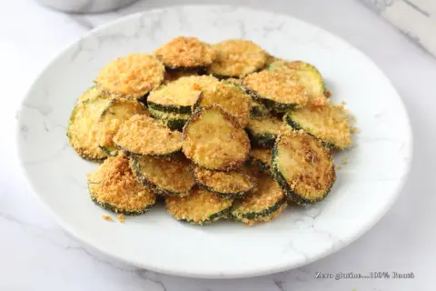 Fette di zucchine croccanti impanate, cotte nella friggitrice ad aria. Un contorno leggero e gustoso.