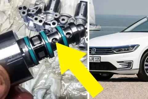 En mekaniker undersöker en del från en dubbeltrapp koppling, troligen relaterad till en vit Volkswagen vid havet.