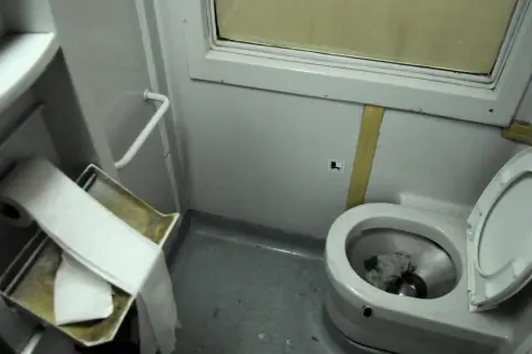 W pociągu toaleta jest w tym małym pomieszczeniu z muszlą klozetową i rolką papieru.
