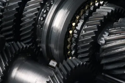 Zbliżenie na metalowe koła zębate i wałki, element skomplikowanej manualnej skrzyni biegów.