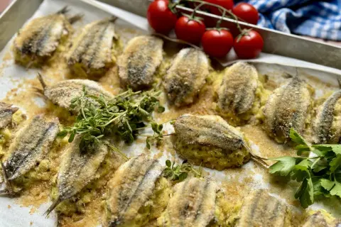 Acciughe ripiene alla ligure, dorate e croccanti, pronte per essere gustate. Un piatto che profuma di mare e tradizione.