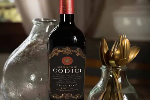 Bottiglia di vino rosso Masserie Codici Primitivo Puglia. Le caratteristiche del negroamaro vino sono evocate dalla terra unica e selvaggia.
