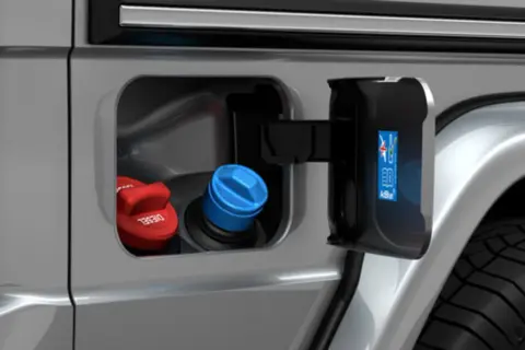 En silverfärgad bil med öppen lucka som visar diesel- och AdBlue-påfyllning.