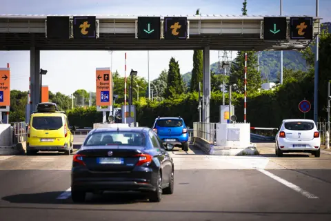Voitures attendant au péage de l'autoroute A49. Panneaux lumineux indiquant les voies.