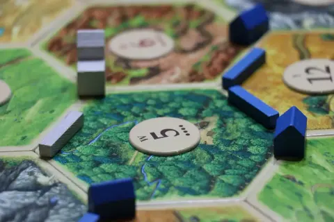 Fragment planszy do gry strategicznej, z niebieskimi domkami i szarymi elementami.