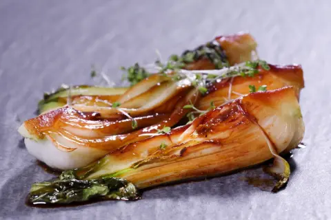 Gebratener Pak Choi mit glänzender Glasur, garniert mit frischen Kräutern. Ein köstliches Pak Choi Rezept, das Lust auf mehr macht.