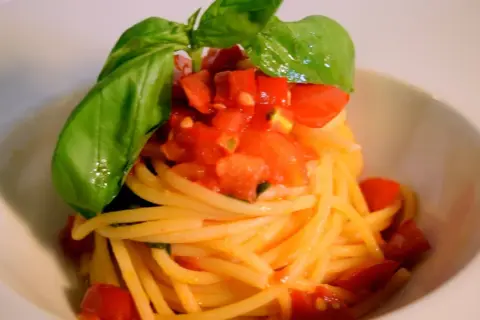 Spaghetti al pomodoro fresco, conditi con pomodoro fresco a cubetti e basilico profumato, un classico intramontabile.