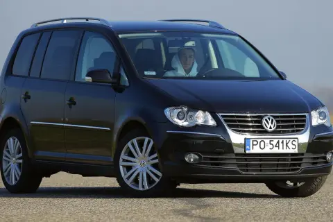 Czarny Volkswagen Touran 2004 z kierowcą w kapturze, widok z przodu.