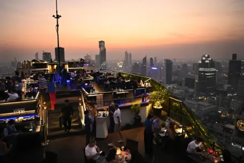 Abendstimmung auf einer Dachterrasse in Bangkok. Ein perfekter Ort, um die Skyline bei einem Drink zu genießen, ideal für einen Kurztrip nach Bangkok in 2 Tagen.