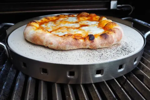 Pyszna pizza z grilla gazowego, z rumianym ciastem i ciągnącym się serem, pieczona na kamieniu.