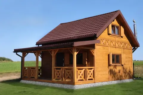 Drewniany domek letniskowy z werandą, idealny na wypoczynek. Zastanawiasz się, ile kosztuje domek letniskowy?