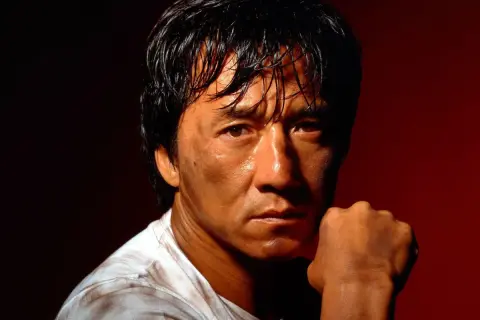 Jackie Chan, med svettig panna och en knuten näve, redo för action i sina filmer.