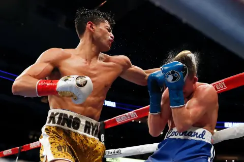 Boxer lands a powerful left hook, sending a spray of sweat and water into the air. This is how to throw a left hook with maximum impact.