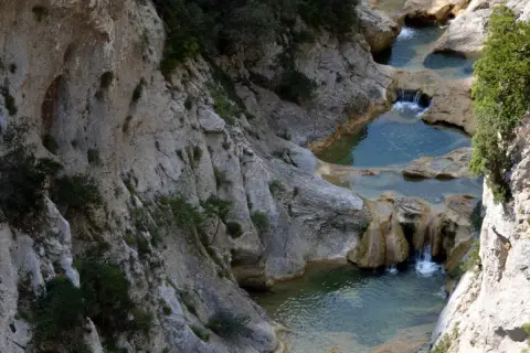 Les gorges de Galamus, un itinéraire spectaculaire avec des cascades et des bassins d'eau turquoise creusés dans la roche.