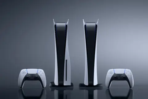 Dwie konsolki PS5 i dwa kontrolery DualSense, prezentujące różne wersje sprzętu.
