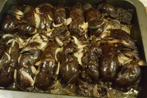 Kaszanka z grilla z cebulą w folii aluminiowej, pieczona do perfekcji. Aromatyczna i soczysta, gotowa do podania.