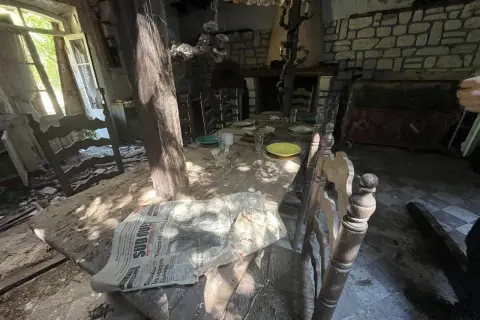 Table dressée dans une maison abandonnée, vestige d'un urbex à Bordeaux. Lumière filtrant par la fenêtre, poussière sur les assiettes.