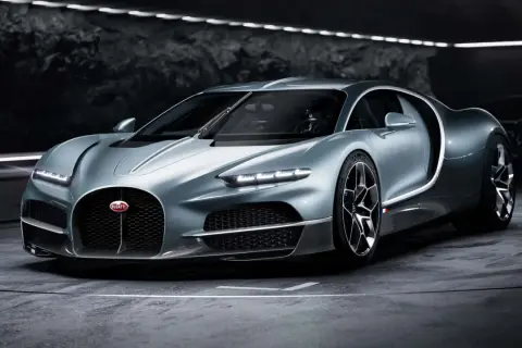 Srebrny Bugatti Tourbillon, symbol luksusu i mocy, prezentuje swoje aerodynamiczne linie w mrocznym wnętrzu.