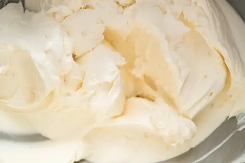 Cremige Buttercreme mit Pudding, die in einer Schüssel aufgeschlagen wird.