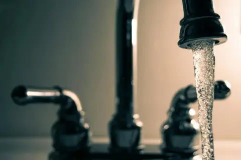 Eau du robinet qui coule, rappelant le danger du chlore. L'eau, source de vie, peut aussi cacher des risques.