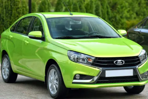 En ljusgrön Lada Vesta står parkerad utomhus.