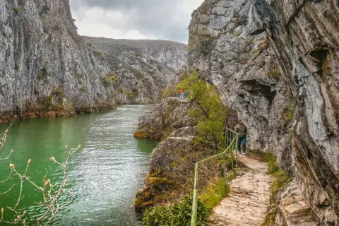 Vandra längs stigen i Matka Canyon, med turkost vatten och dramatiska klippor.