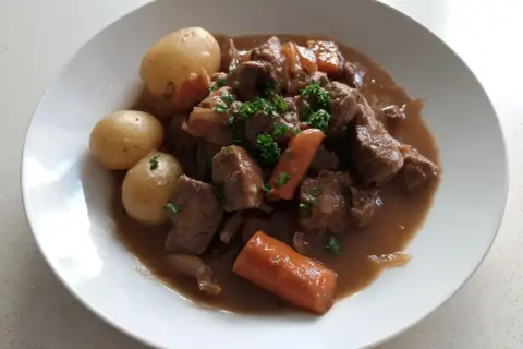 En härlig fransyska gryta med möra köttbitar, mjuka potatisar och saftiga morötter, toppad med färsk persilja.