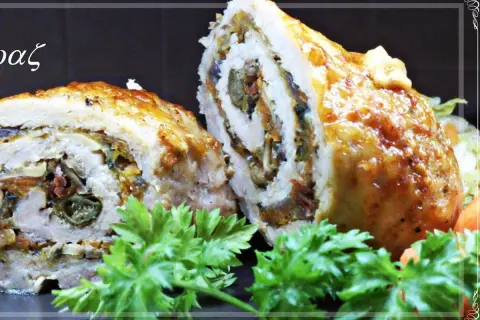 Roladki schabowe pieczone w naczyniu, z widocznym nadzieniem z warzyw i suszonych pomidorów, ozdobione natką pietruszki.