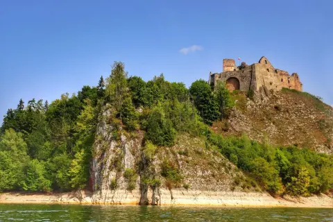Ruiny zamku na wzgórzu, otoczone zielenią, nad wodą. Niezwykłe czorsztyn atrakcje czekają na odkrycie.