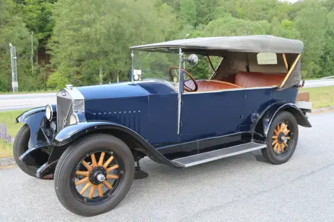 En mörkblå Volvo Car AB cabriolet från tidigt 1900-tal med bruna lädersäten och träekerhjul.