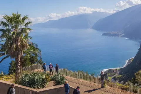 Blick auf Ribeira da Janela mit Palmen und dem tiefblauen Meer. Touristen genießen die Aussicht auf die Küste und die Berge.
