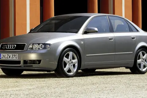Srebrne Audi A4 B6 1.9 TDI 130KM na tle pomarańczowej ściany.