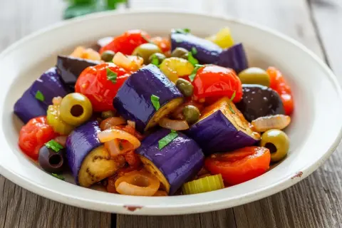 En härlig caponata med aubergine, tomater, oliver och kapris. Ett perfekt recept för en smakrik sallad.