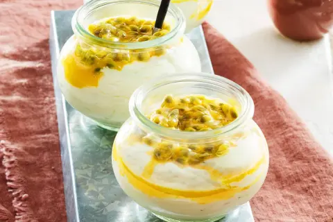 Zwei Gläser mit cremigem Dessert und Passionsfrucht-Topping.
