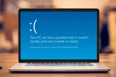 Laptop z niebieskim ekranem Windows 11, wyświetlającym komunikat o błędzie HAL_INITIALIZATION_FAILED.