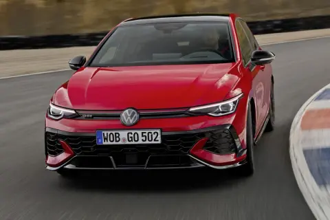 Czerwony Golf GTI Edition 50 na torze wyścigowym, z kierowcą za kierownicą, gotowy do ostrej jazdy.