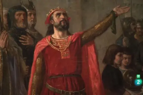 Alfonso V de Portugal, coronado y con capa roja, levanta su mano ante una corte.