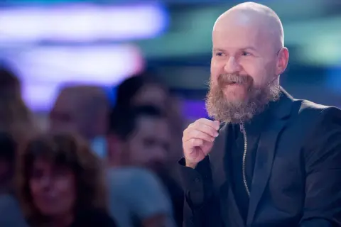 Alexander Bard, med sitt karaktäristiska skägg och skalliga huvud, ler och gestikulerar under ett event.