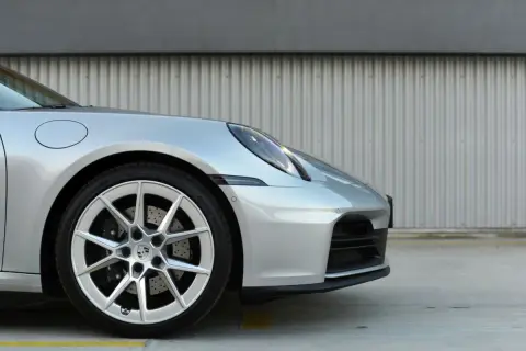 Srebrny Porsche 911 Carrera 4S z felgami i zaciskami hamulcowymi.