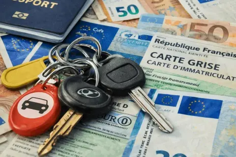 Kluczyki do auta, paszport i dokumenty, w tym karta pojazdu (carte grise) i pieniądze, sugerują podróż lub zakup samochodu. RLU rejestracja wkrótce!