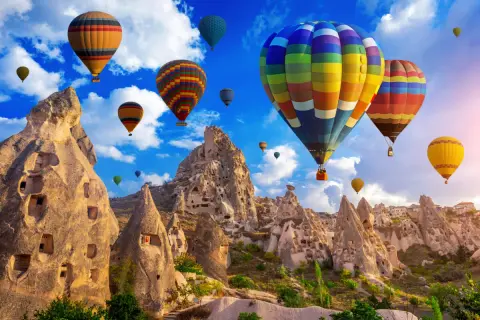 Kolorowe balony unoszą się nad Kapadocją, tworząc magiczny widok. Nawet w grudniu turcja pogoda w grudniu pozwala na takie niezwykłe przeżycia.