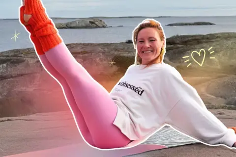 Kobieta w różowych legginsach i pomarańczowych ocieplaczach ćwiczy pilates na zewnątrz.
