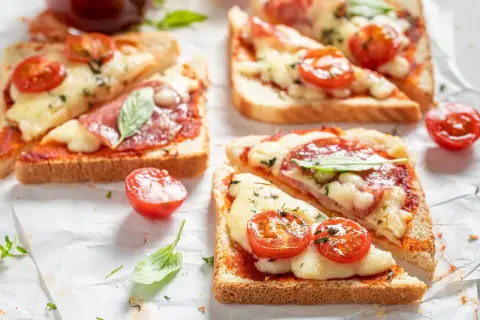 Pyszne tosty z piekarnika z serem, pomidorkami i bazylią. Idealna przekąska na szybki lunch.