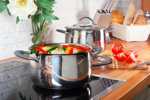 Casserole remplie de légumes colorés sur une plaque à induction, prête à être cuisinée.