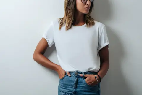 Frau in Jeans und einem weißen T-Shirt, das leicht gerollt ist. Das T-Shirt hat ein geringes Gewicht und ist bequem.