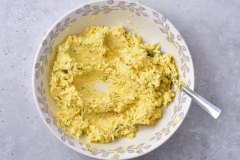 Mieszanka jajeczna z ziołami, przygotowana jako pasta jajeczna bez majonezu, w misce z ozdobnym brzegiem.