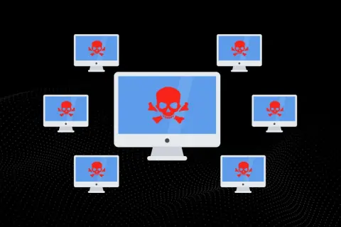 Wiele komputerów z czerwonym symbolem czaszki i skrzyżowanych kości na niebieskim tle, sugerujące atak DDoS.