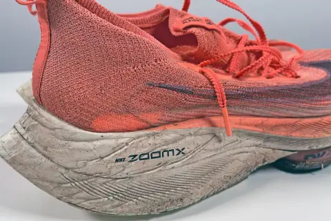 Scarpa da running Nike ZoomX arancione, usata ma ancora performante. La sua durata è testimoniata dai chilometri percorsi.